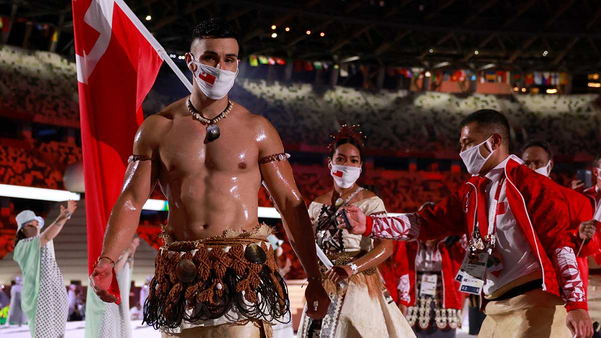 Pita Tufatofua con abdomen descubierto, embarrado con aceite de coco, sosteniendo la bandera en los Juegos Olímpicos de Tokio 2020 Foto: AFP